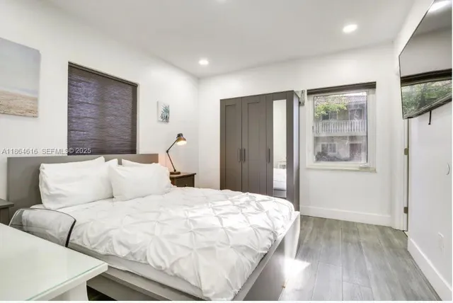 a bedroom with a large bed and a flat tv screen