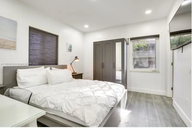 a bedroom with a large bed and a flat tv screen