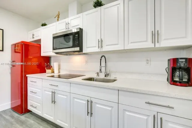 a kitchen with stainless steel appliances granite countertop white cabinets a sink and dishwasher