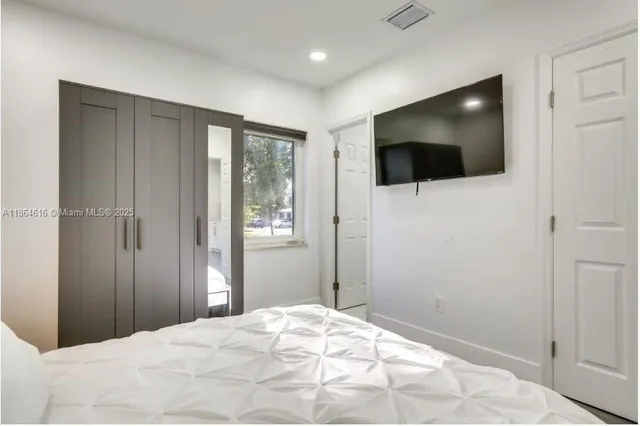 a view of a livingroom with wooden floor and flat screen tv