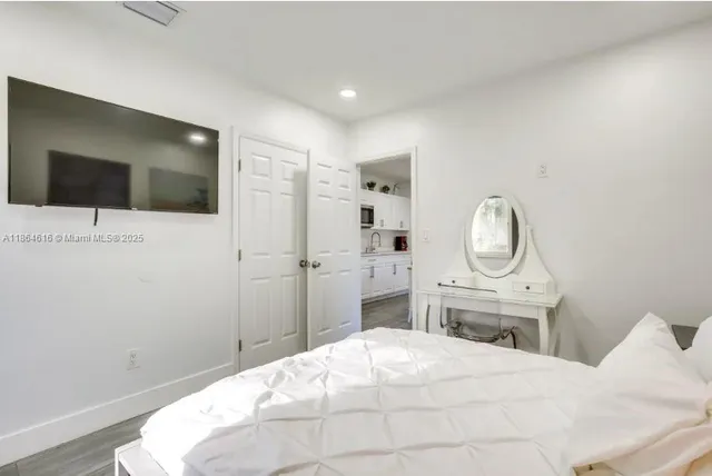 a spacious bedroom with a bed and a flat screen tv