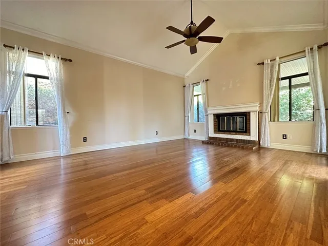 a view of a livingroom with wooden floor and a ceiling fan
