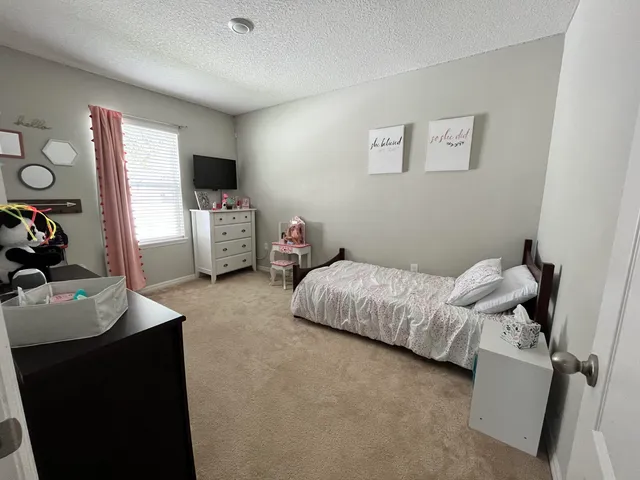 a bedroom with furniture and a flat screen tv
