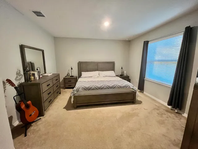 a bedroom with a bed and a large mirror