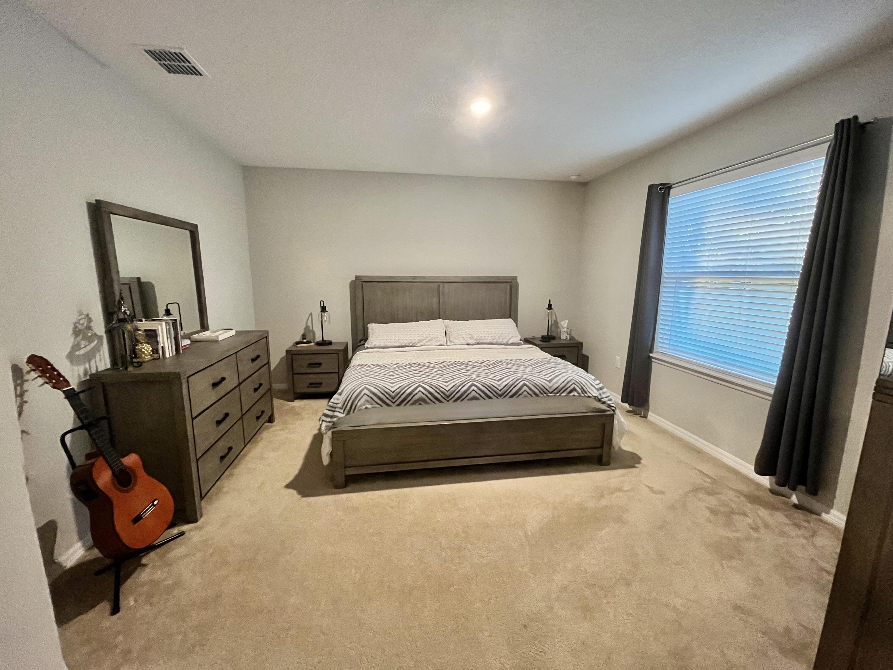 1973 Southwest Libra Lane Port St. Lucie, FL 34984 - Photo 9 of 16 a bedroom with a bed and a large mirror