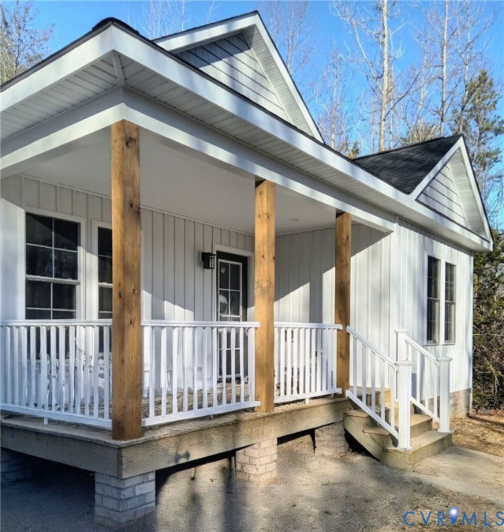 View of exterior entry with covered porch, a shing