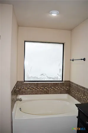 a bathroom with a bathtub and window
