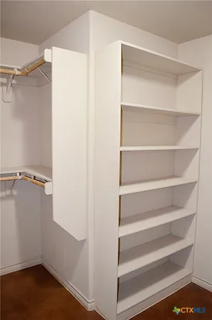a view of walk in closet with empty racks