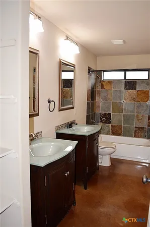 a bathroom with a sink vanity granite toilet tub and shower