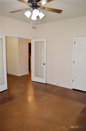 an empty room with a ceiling fan and a window