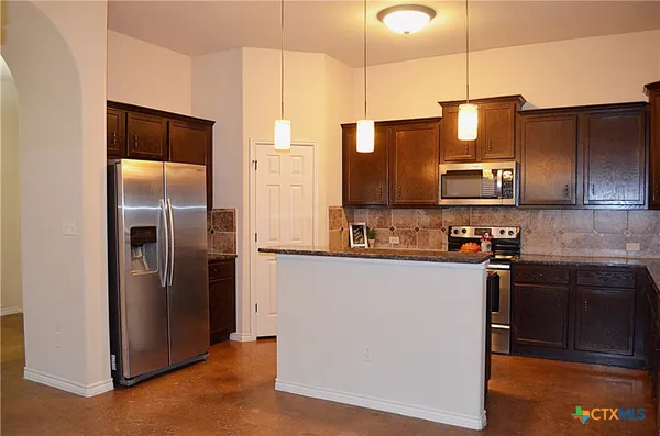 a kitchen with stainless steel appliances granite countertop a refrigerator and a sink