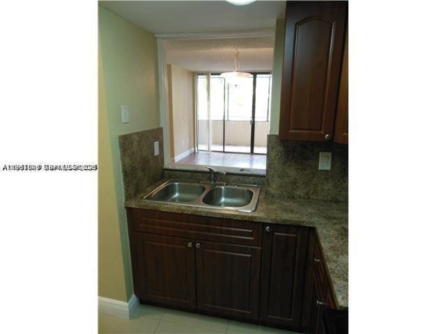 8335 Southwest 152nd Avenue, Unit B308 Miami, FL 33193 - Photo 3 of 9 a kitchen that has a sink and a stove