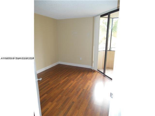 8335 Southwest 152nd Avenue, Unit B308 Miami, FL 33193 - Photo 4 of 9 a view of an empty room with wooden floor and a window