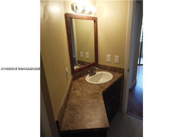 8335 Southwest 152nd Avenue, Unit B308 Miami, FL 33193 - Photo 6 of 9 a bathroom with a sink and a mirror