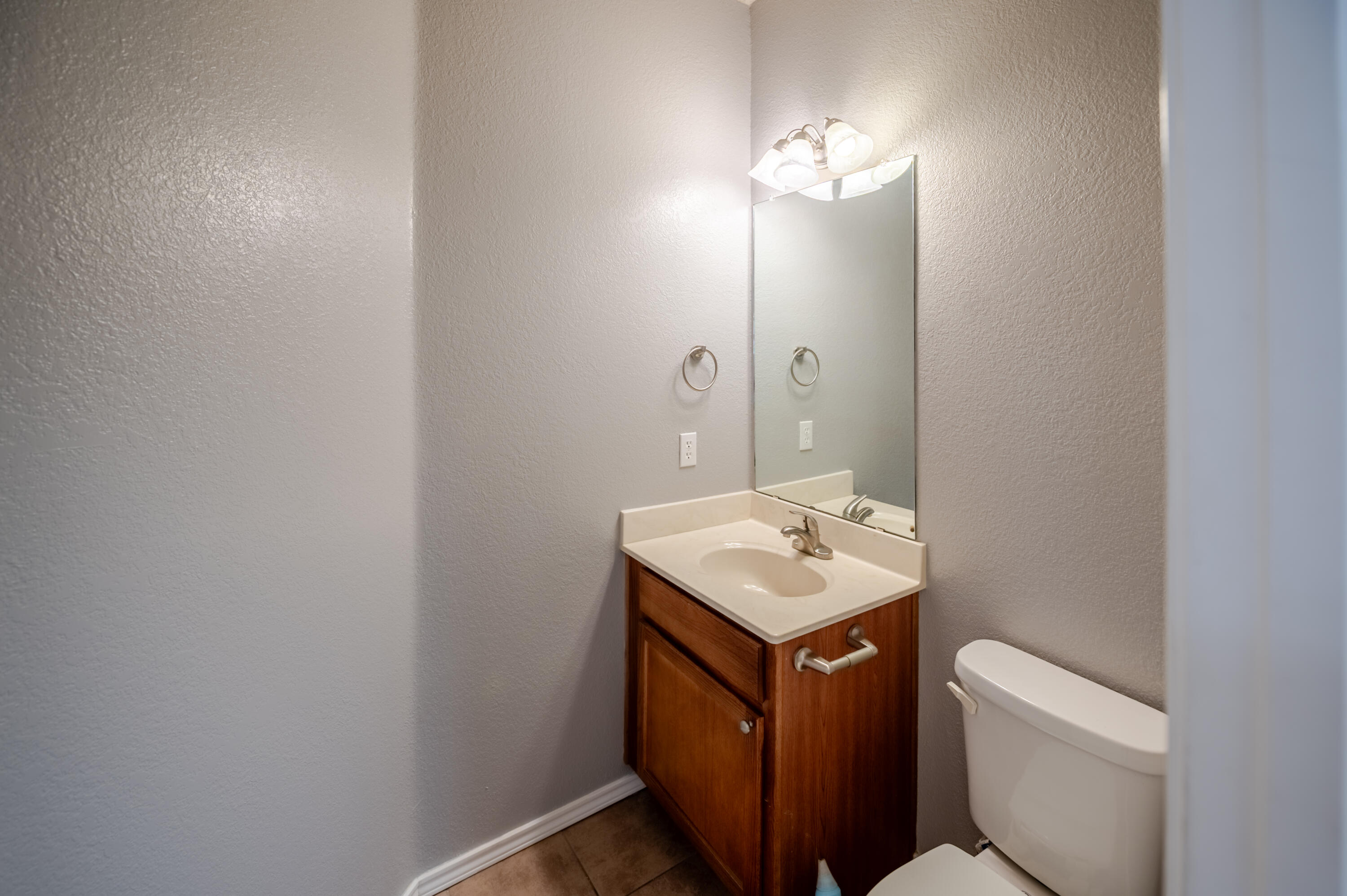 2111 Main Street, Unit 1 Lubbock, TX 79401 - Photo 19 of 36 a bathroom with a toilet sink and mirror