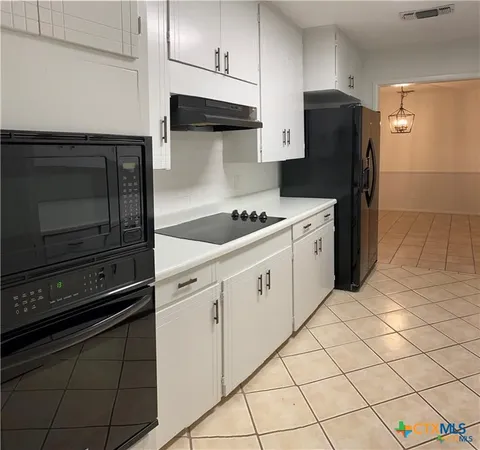a close view of a sink and cabinets in a kitchen