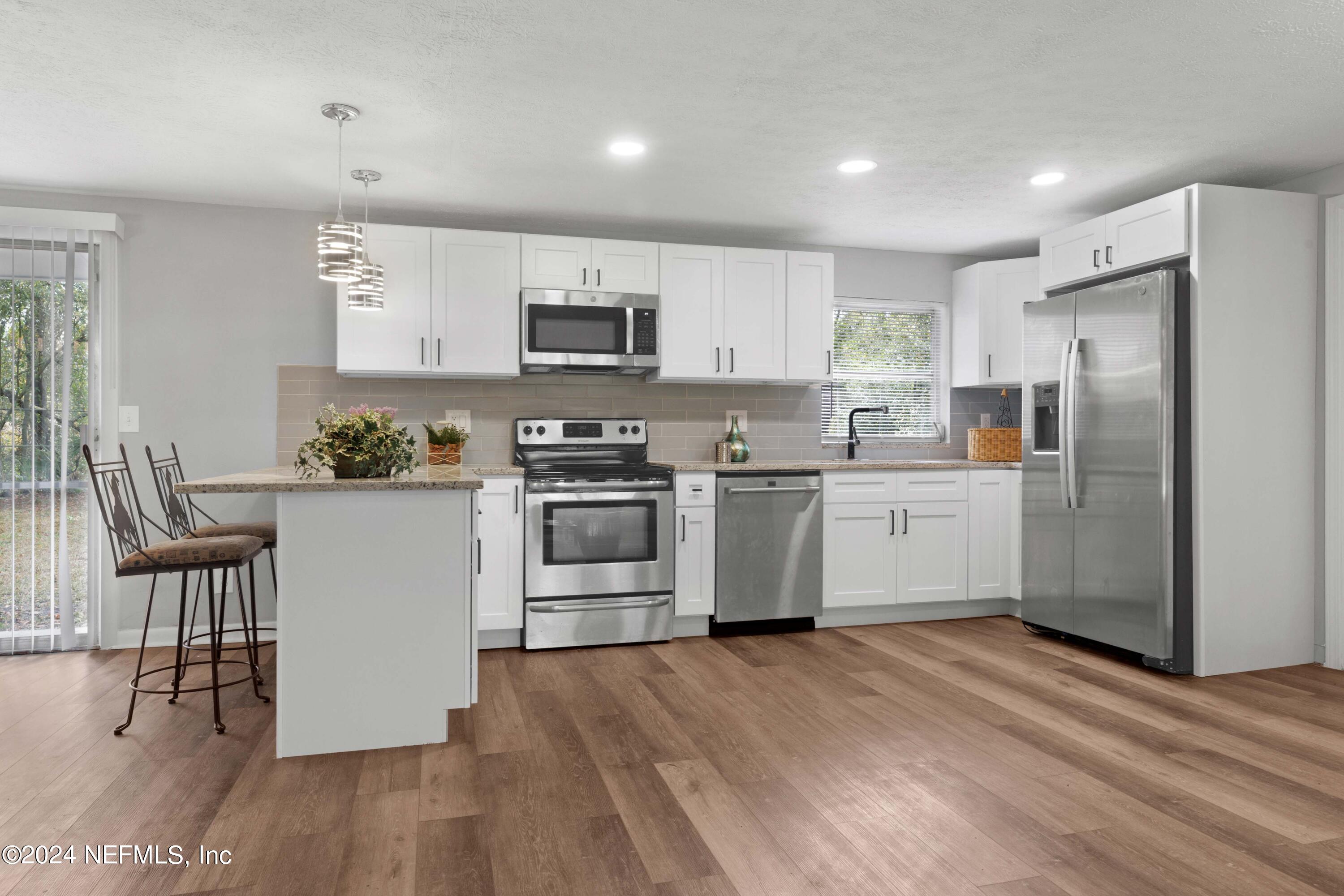 10942 Player Road Jacksonville, FL 32218 - Photo 8 of 39 a kitchen with white cabinets and stainless steel appliances