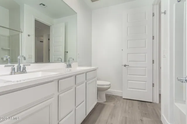 a bathroom with a granite countertop sink toilet and a mirror
