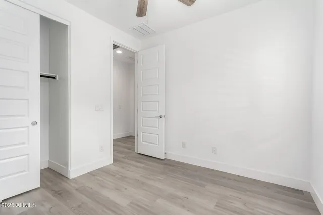 an empty room with wooden floor and white doors