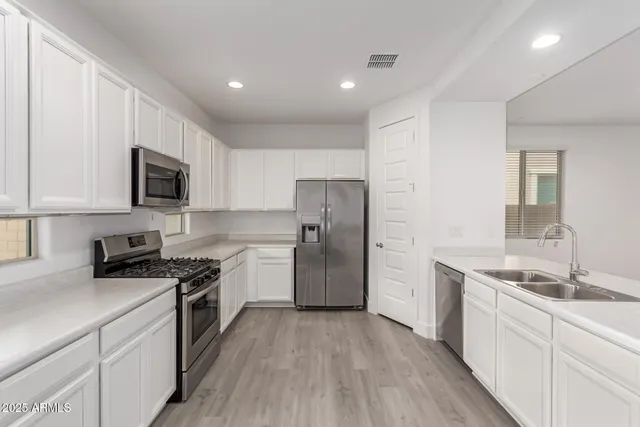 a kitchen with a sink a stove a refrigerator and cabinets