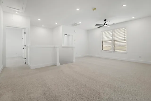 an empty room with a window and a ceiling fan