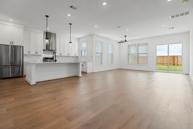 a kitchen with stainless steel appliances white cabinets and a refrigerator