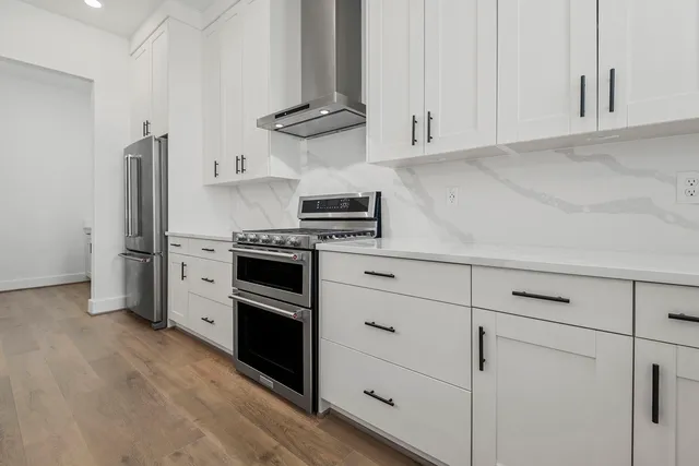 a kitchen with stainless steel appliances granite countertop a stove a sink dishwasher and a stove with wooden floors