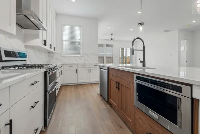 a kitchen with kitchen island a refrigerator sink and cabinets