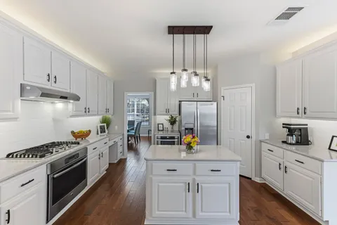 a kitchen with stainless steel appliances a sink stove and cabinets