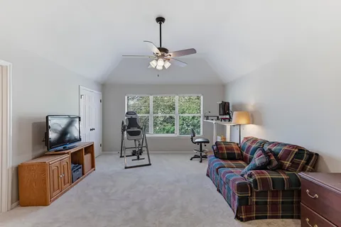 a living room with furniture a flat screen tv and a window