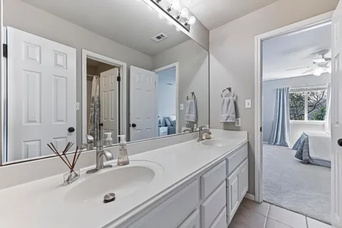 a bathroom with double vanity sinks and a mirror