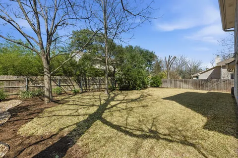a view of a yard with wooden fence