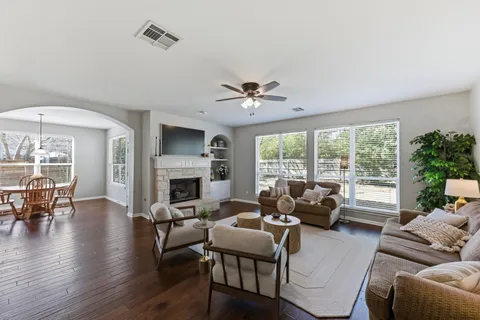 a living room with furniture a fireplace and a large window