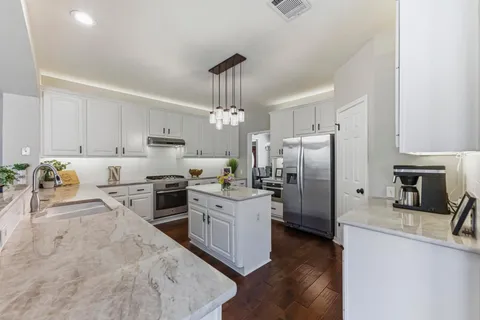 a kitchen with refrigerator a oven and a sink