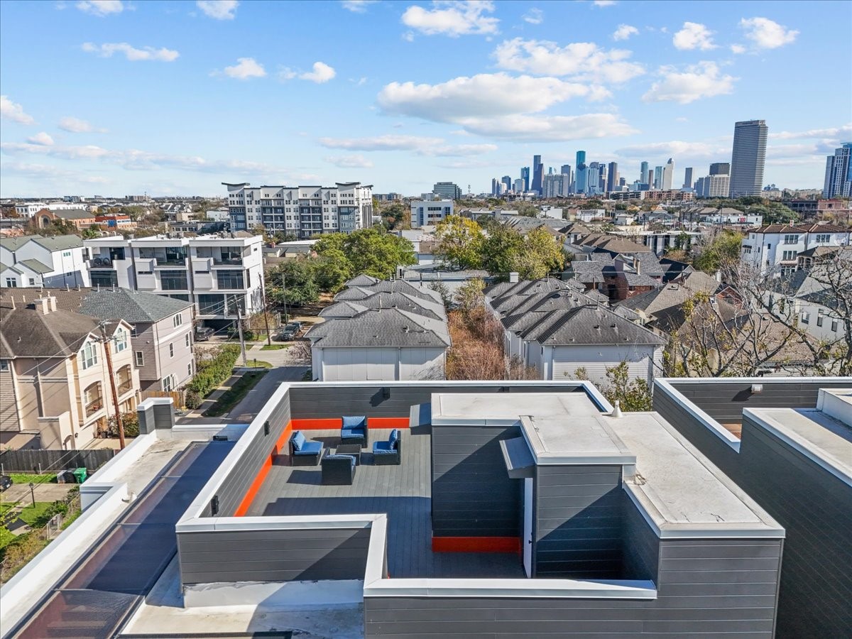 516 Reinerman Street Houston, TX 77007 - Photo 6 of 42 Modern rooftop terrace with seating, offering a stunning city skyline view. Ideal for relaxation and entertaining in a vibrant neighborhood setting.