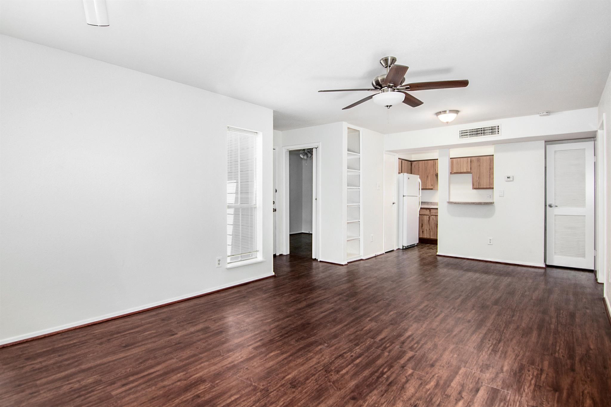 18519 Egret Bay Boulevard, Unit 1708 Webster, TX 77058 - Photo 5 of 27 an empty room with wooden floor ceiling fan and windows