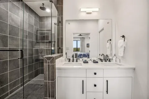 a bathroom with a sink mirror and shower