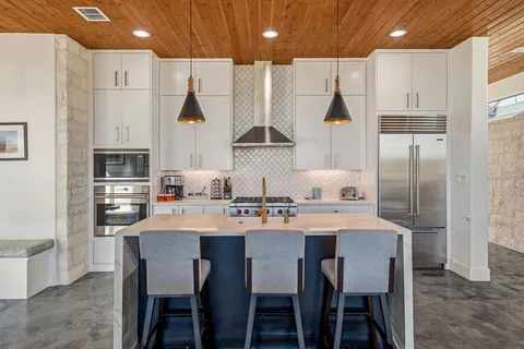 a kitchen with stainless steel appliances a table chairs and a refrigerator