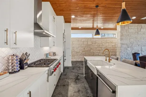 a kitchen with stainless steel appliances a sink a stove and a refrigerator