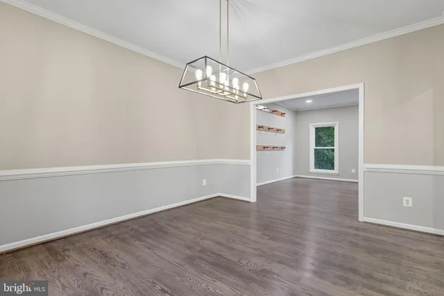 an empty room with windows and chandelier fan