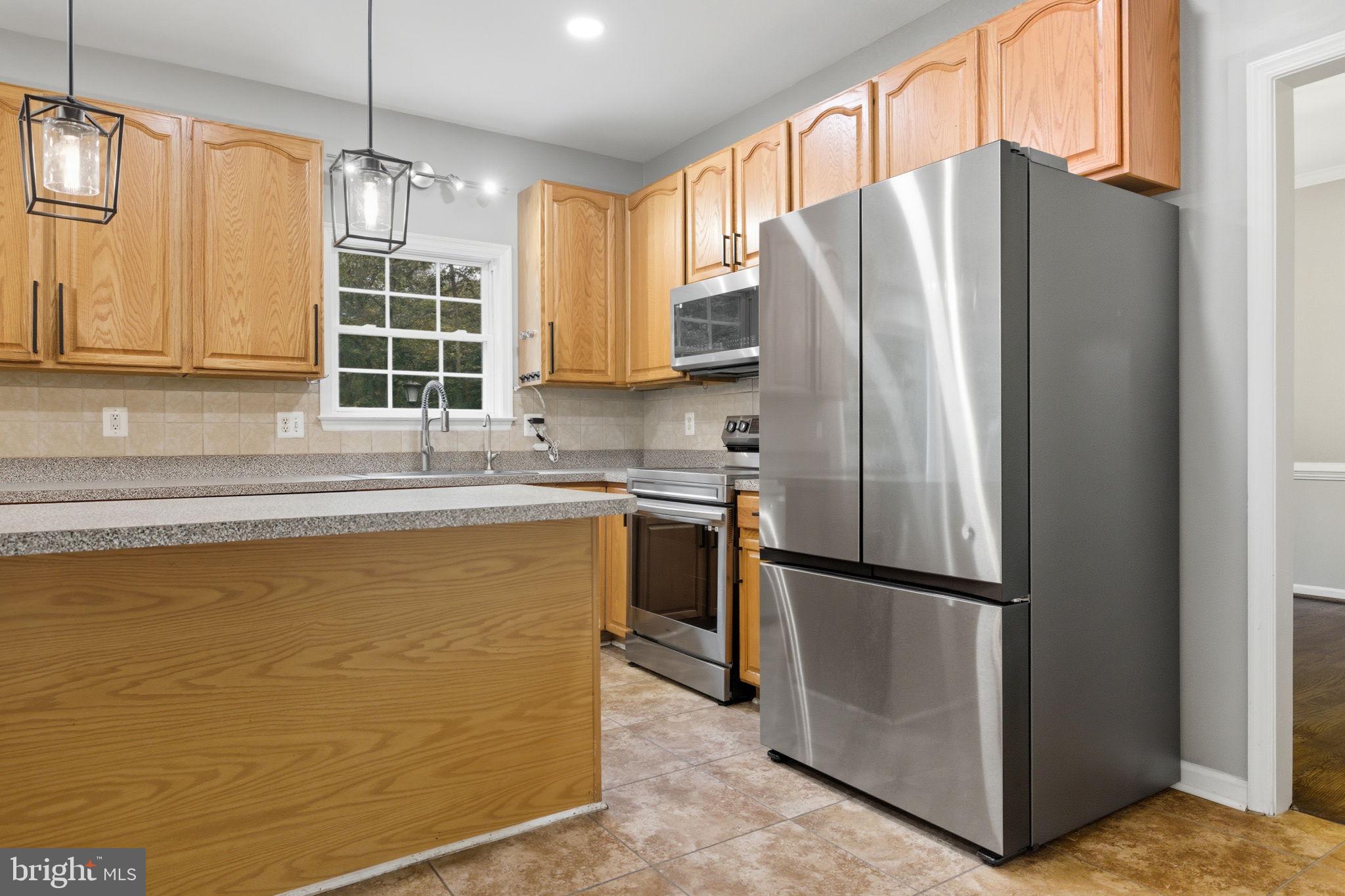 6363 Yates Ford Road Manassas, VA 20111 - Photo 44 of 67 a kitchen with stainless steel appliances granite countertop a refrigerator a sink and a stove
