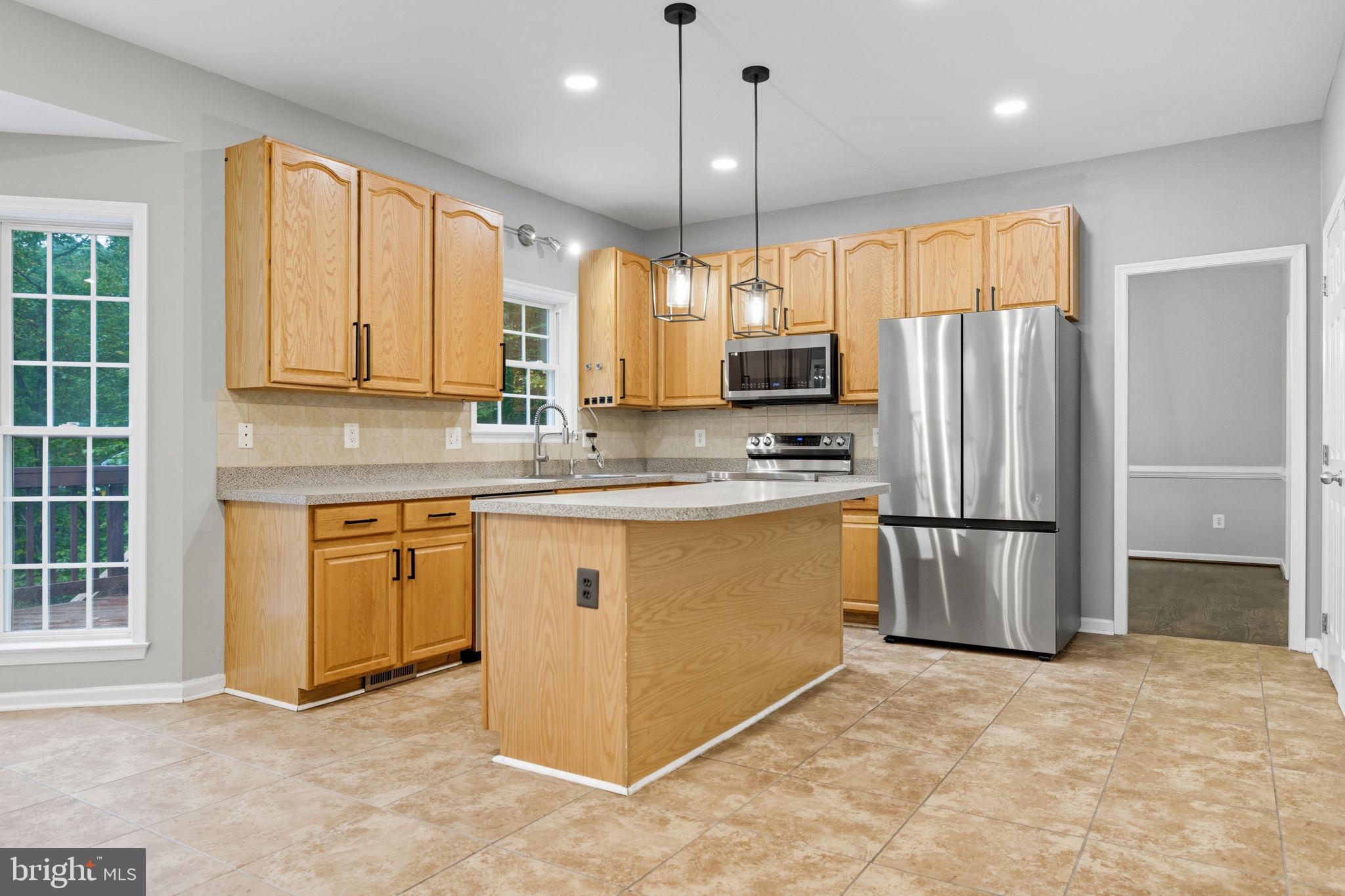 6363 Yates Ford Road Manassas, VA 20111 - Photo 46 of 67 a kitchen with stainless steel appliances granite countertop a refrigerator a sink a stove and a refrigerator with wooden floor