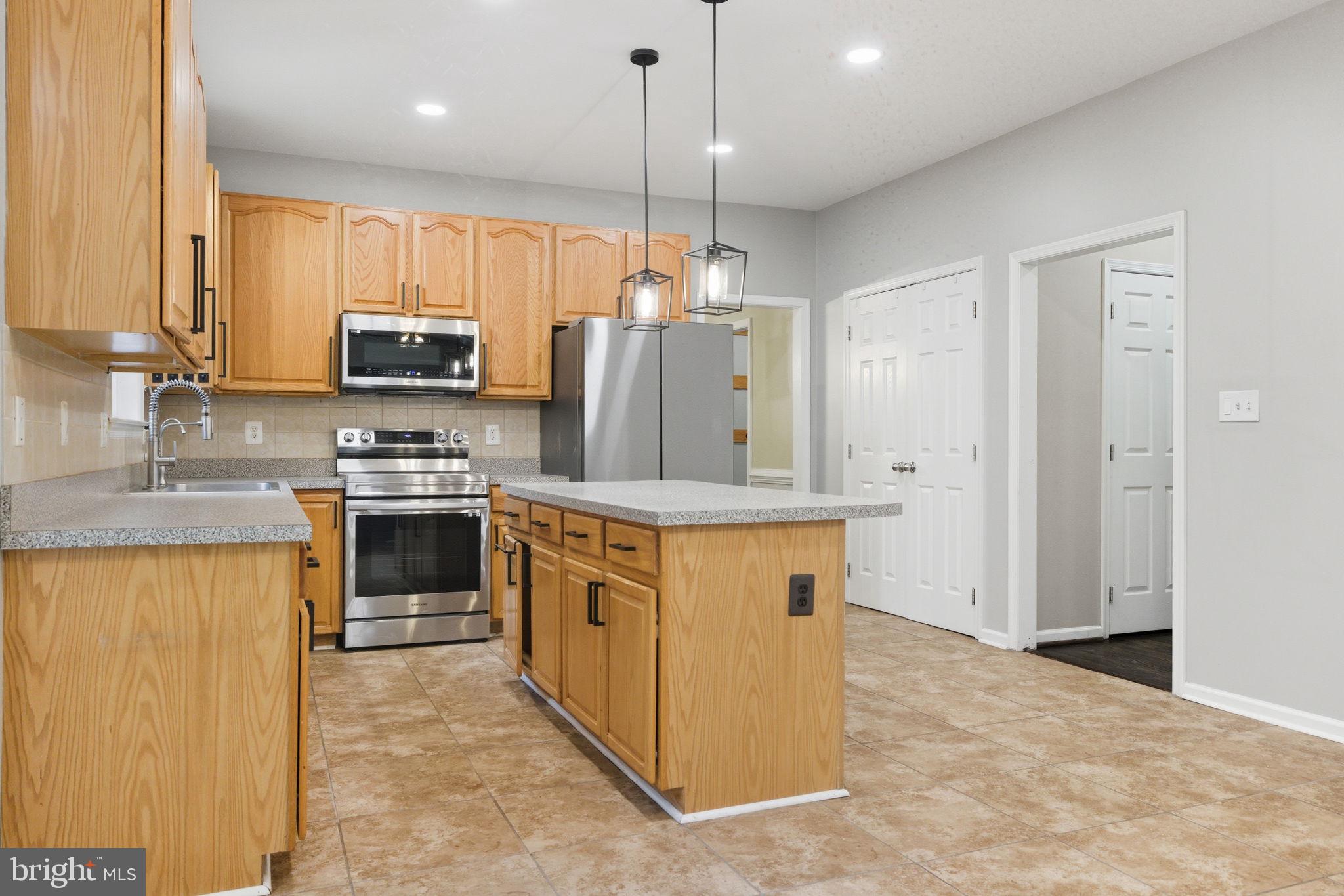 6363 Yates Ford Road Manassas, VA 20111 - Photo 47 of 67 a kitchen with kitchen island a sink stove and refrigerator