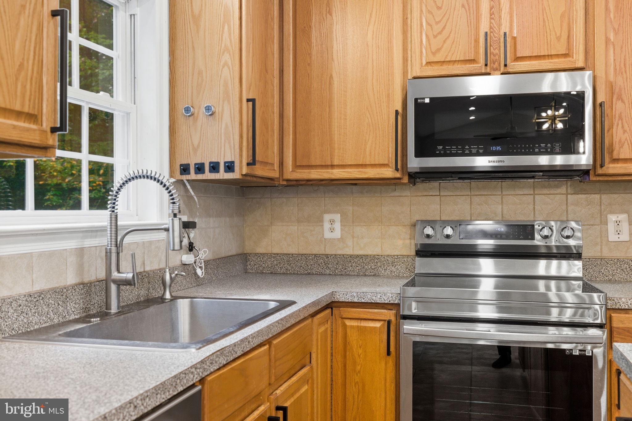 6363 Yates Ford Road Manassas, VA 20111 - Photo 48 of 67 a kitchen with stainless steel appliances granite countertop a stove and a sink