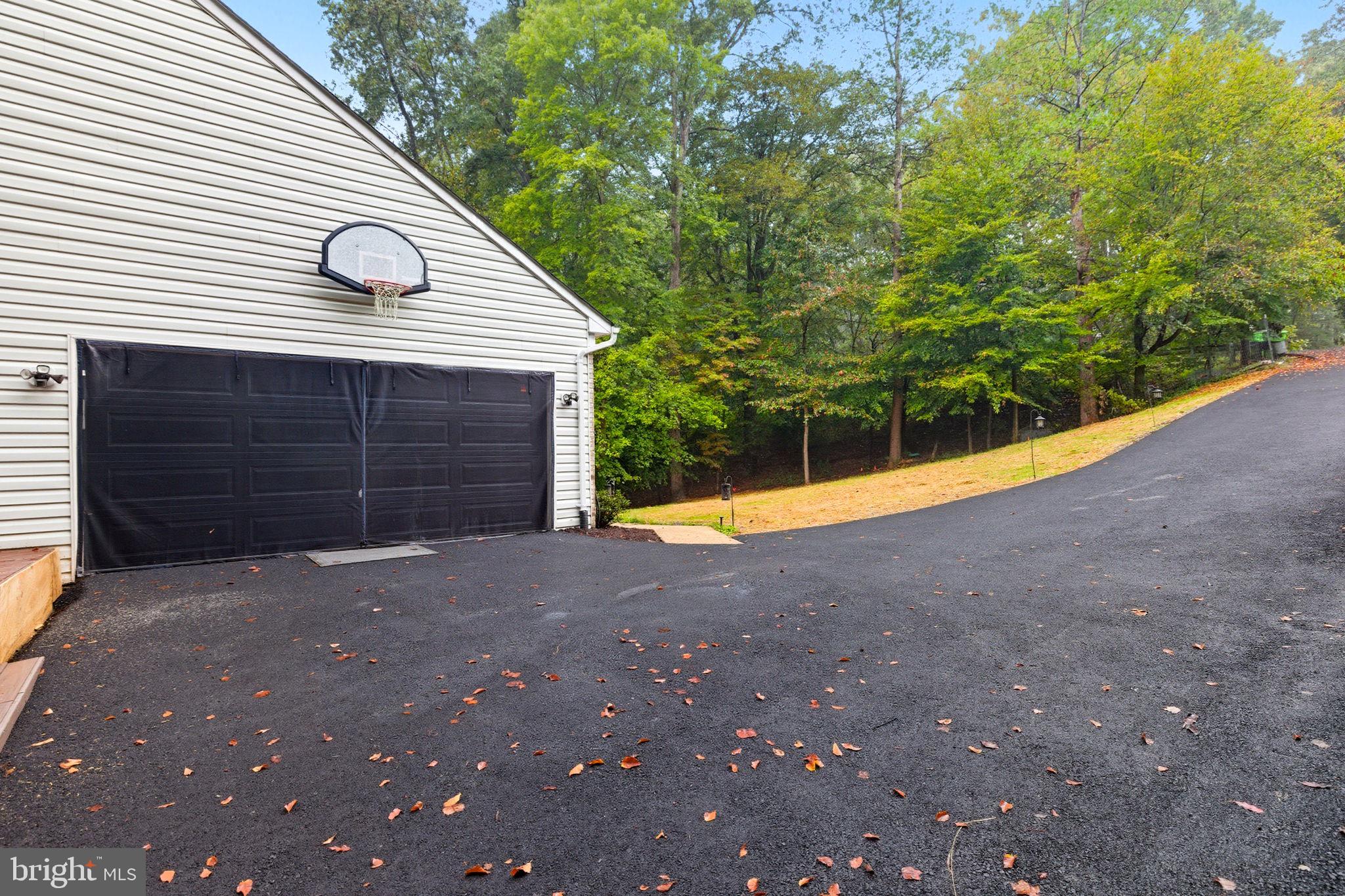 6363 Yates Ford Road Manassas, VA 20111 - Photo 55 of 67 a view of backyard with large trees and brick wall