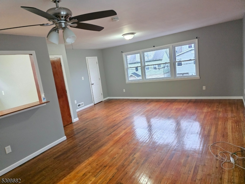 97 Goodwin Avenue Newark, NJ 07112 - Photo 12 of 20 a view of an empty room with a window and wooden floor