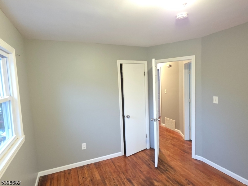 97 Goodwin Avenue Newark, NJ 07112 - Photo 16 of 20 an empty room with wooden floor and a window