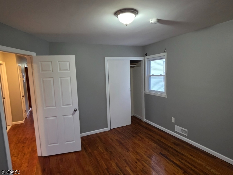 97 Goodwin Avenue Newark, NJ 07112 - Photo 17 of 20 an empty room with wooden floor and closet
