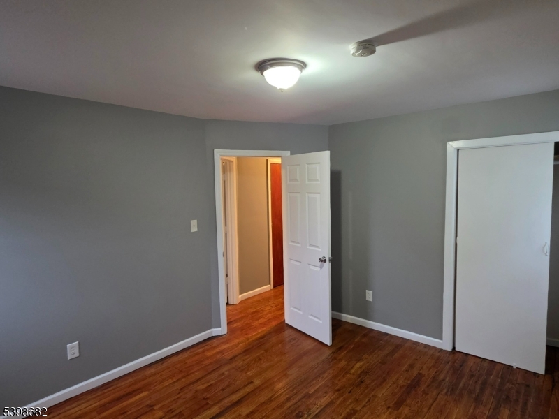 97 Goodwin Avenue Newark, NJ 07112 - Photo 18 of 20 an empty room with wooden floor and windows