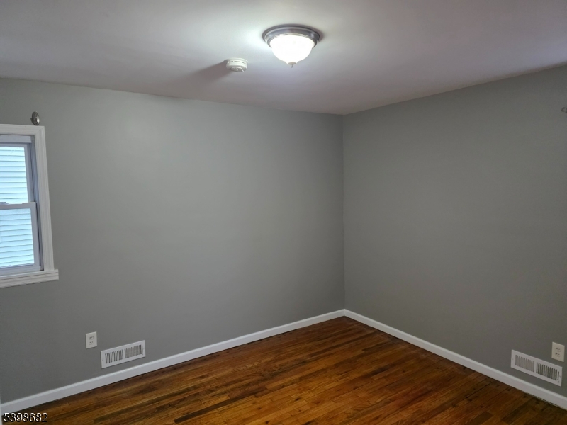 97 Goodwin Avenue Newark, NJ 07112 - Photo 19 of 20 a view of an empty room with wooden floor and a window